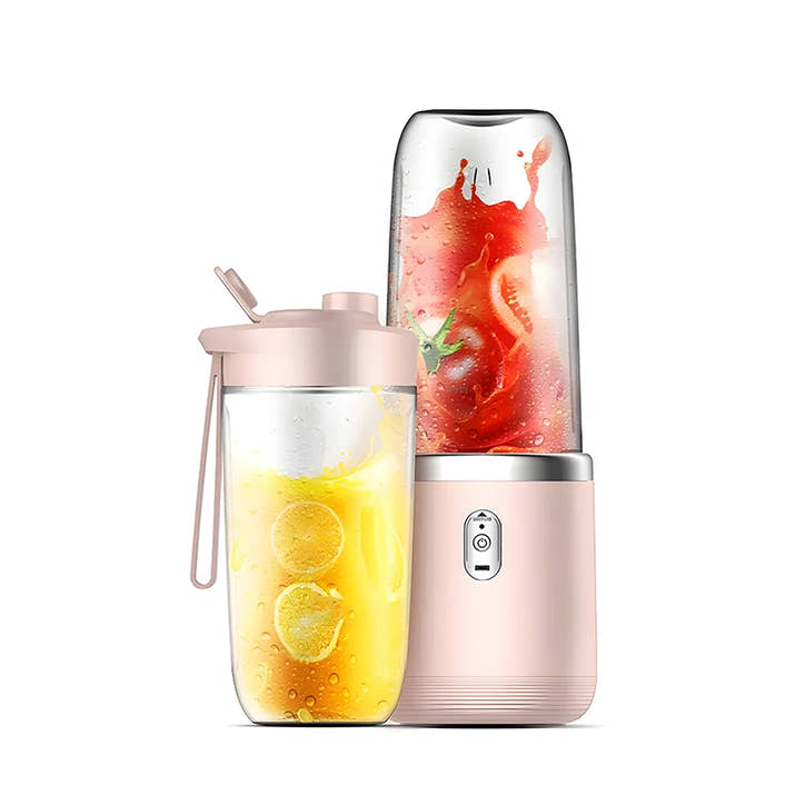 Portable blender with a pink lid and body, containing a yellow liquid and sliced fruit.