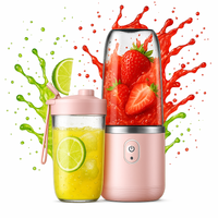 Pink portable blender with a glass container filled with a yellow drink and lime slices, surrounded by colorful splashes of red and green.